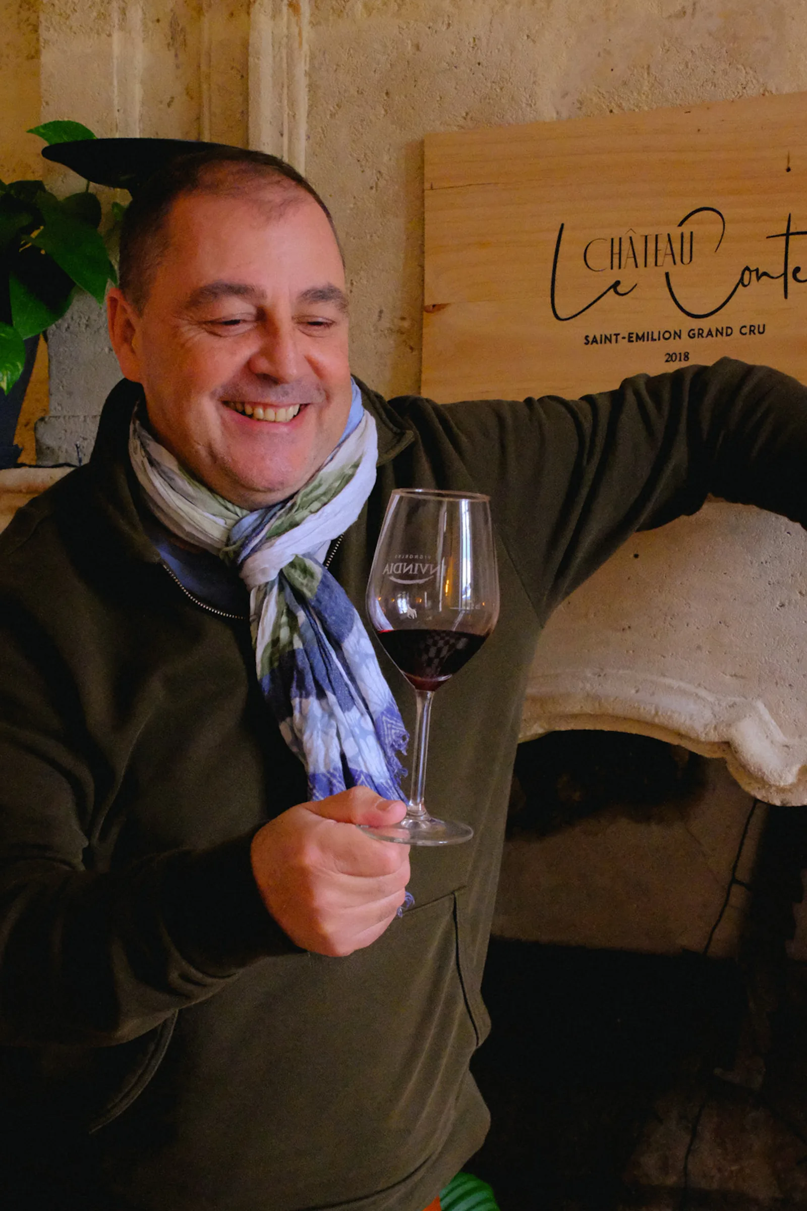 Le créateur de Creativini, un verre de vin rouge à la main, dans son chai
